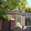 Image: Old stone building with blue plaque on the brick wall outside