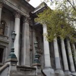 Image: large grey building with pillars at the entrance