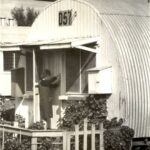 Image: woman at door of curved tin building