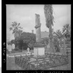 Image: stone column inside fence, house in background