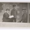 Image: A woman and two men on a verandah