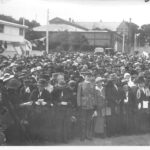 Image: crowds gathering in front of buildings