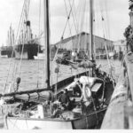 Image: small boat arriving at wharf