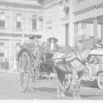 Image: Two women and a child inside a decorated horse-pulled cart