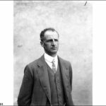 Image: A photographic portrait of a man wearing a suit with waistcoat