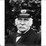 Image: Black and white photograph of elderly man wearing a hat