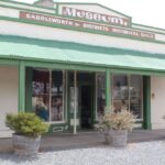 Image: Colour photo of a building's façade with cream and green colour scheme, a museum sign features on the front.