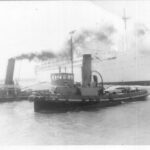 Image: Two tugboats, one of which has the name ‘Yelta’ painted on its bow, tow a larger ship named ‘Himalaya’