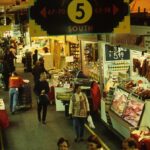 Image: groups of people walking through market stalls