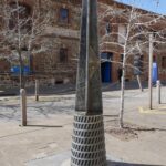 Image: metal post in front of large stone building