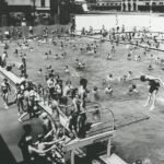 Image: large number of children in and around swimming pool