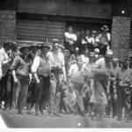 Image: a group of men gathered outside an abattoir