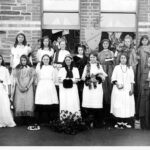 Image: a large group of girls in costumes representing the people of Australia for Empire Day celebrations, circa 1915