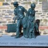 Image: bronze sculpture of family group with suitcase