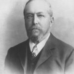 Black and white head shot of middle aged man with beard