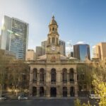 Image: sandstone building with clock tower in centre