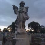 Image: Stone angel with graves visible in the background