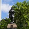 Image: Bronze statue of a man atop a granite pillar