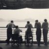 Image: silhouette of five men from behind, standing on board a ship