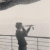 Image: boy holding telescope and looking out over ocean